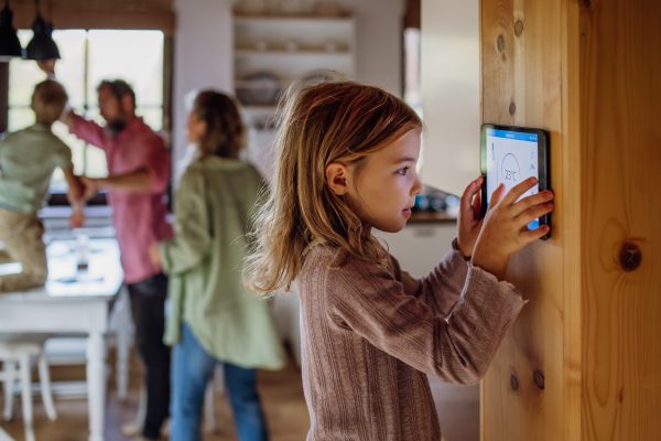 Girl looking at the smart thermostat at home due to WiFi Setup Whole-Home Coverage